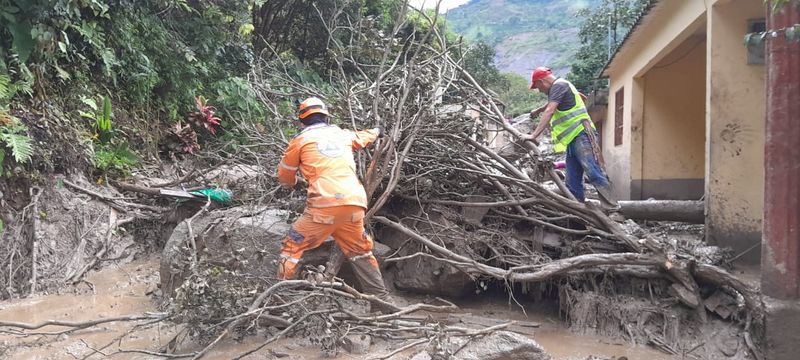&copy; Reuters. عاملان يزيلان شجرة عقب انهيار أرضي في كيتامي بكولومبيا في صورة تم توزيعها يوم الثلاثاء. صورة لرويترز من الدفاع المدني الكولومبي. يحظر إعادة 