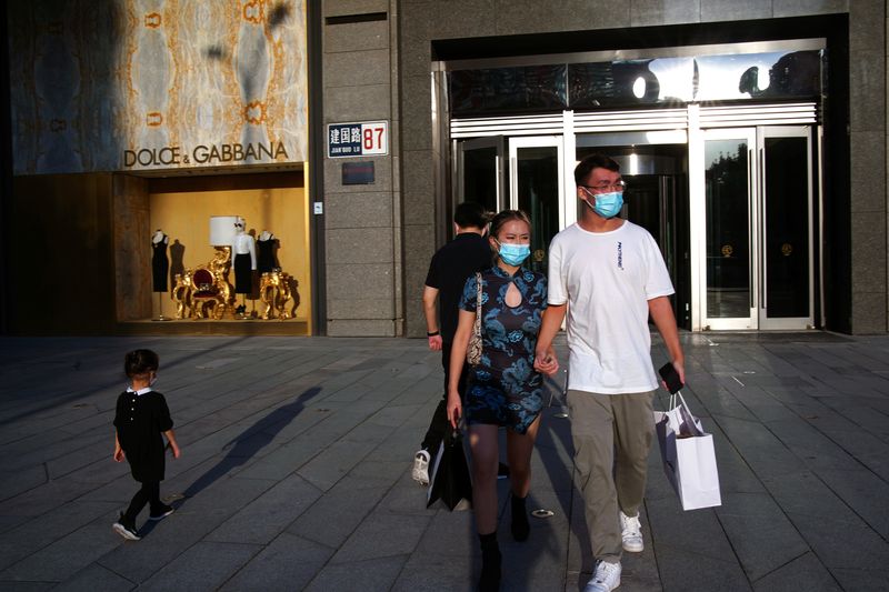 &copy; Reuters. FILE PHOTO: People wearing face masks following the COVID-19 outbreak walk out of a shopping mall in Beijing, China September 19, 2020. Picture taken September 19, 2020. REUTERS/Tingshu Wang