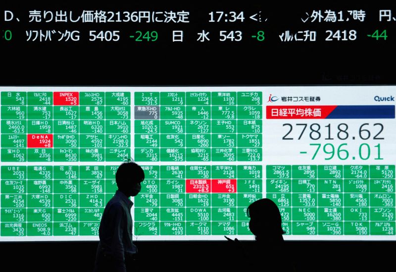 &copy; Reuters. شخصان يمران أمام لوحة إلكترونية تعرض بيانات مؤشر نيكي الياباني في طوكيو يوم 14 سبتمبر أيلول 2022. تصوير: إيسي كاتو -رويترز.