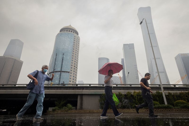 &copy; Reuters. FILE PHOTO: People walk in the Central Business District on a rainy day in Beijing, China, July 12, 2023. REUTERS/Thomas Peter