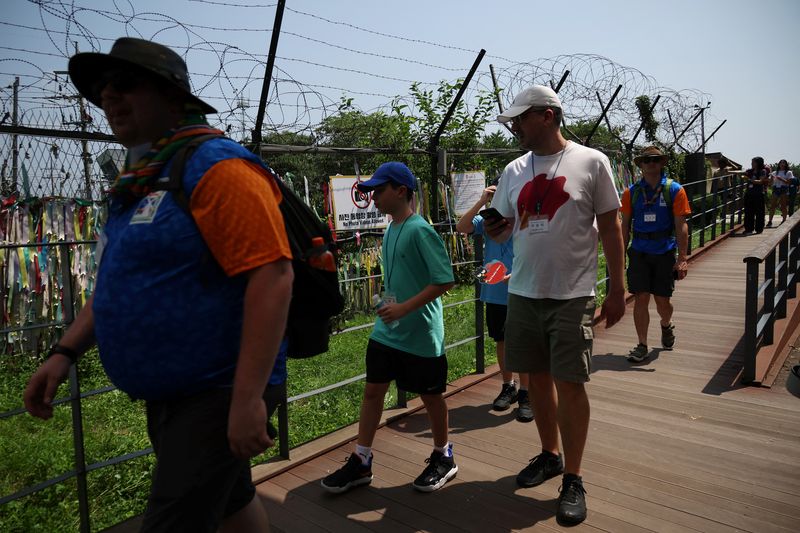 &copy; Reuters. Turistas extranjeros que participan en un recorrido por la DMZ caminan junto a una valla militar cerca de la zona desmilitarizada que separa las dos Coreas, en Paju, Corea del Sur. 19 de julio de 2023. REUTERS/Kim Hong-Ji