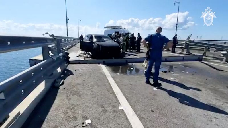 &copy; Reuters. محققون وأعضاء من خدمات الطوارئ الروسية بالقرب من موقع سيارة محطمة عقب هجوم مزعوم على جسر القرم في صورة ثانبة مأخوذة من مقطع فيديو يوم 17 يولي