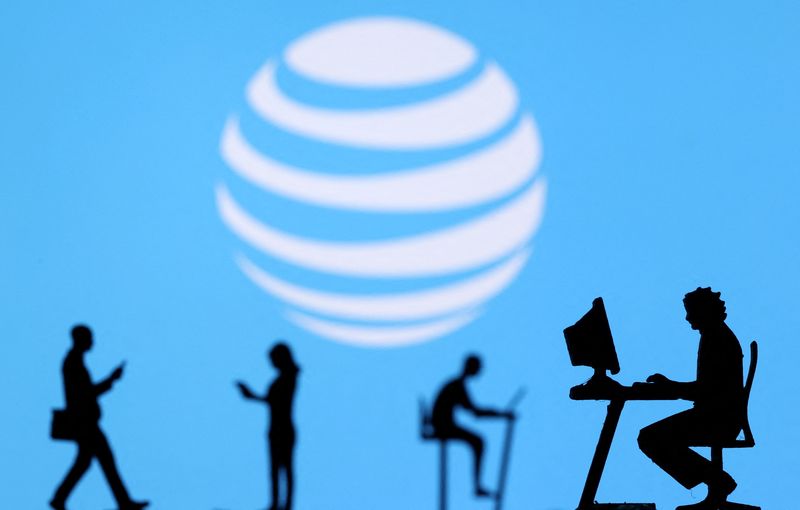 &copy; Reuters. FILE PHOTO: Small toy figures with laptops and smartphones are seen in front of displayed AT&T logo, in this illustration taken December 5, 2021. REUTERS/Dado Ruvic/Illustration/File Photo