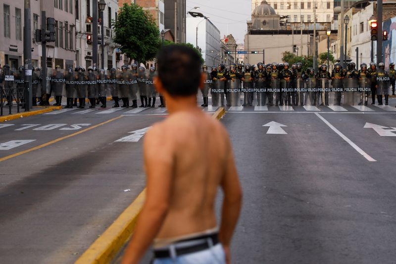 &copy; Reuters. FOTO DE ARCHIVO-Un manifestante se enfrenta a agentes de policía mientras hacen guardia durante una marcha contra el gobierno de la presidenta de Perú, Dina Boluarte, en la que los manifestantes piden una huelga nacional indefinida, en Lima, Perú. 9 de