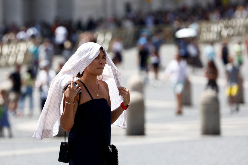 &copy; Reuters. امرأة تسيير خلال موجة حارة علي إيطاليا في الفاتيكان يوم الأربعاء. تصوير: ريمو كاسيلي - رويترز. 
