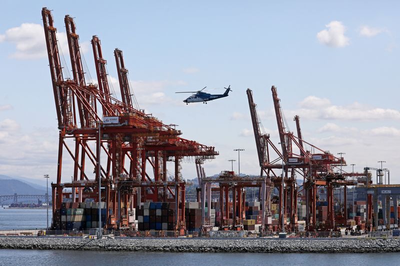 &copy; Reuters. FILE PHOTO: A helicopter passes idle shipping cranes towering over stacked containers during a strike by the International Longshore and Warehouse Union Canada (ILWU) at Canada's busiest port of Vancouver, British Columbia, Canada, July 11, 2023. REUTERS/