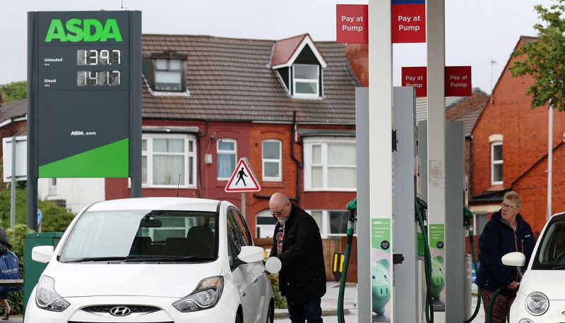 &copy; Reuters. FILE PHOTO: People put fuel in their cars at a filling station at an ASDA supermarket in Birkenhead, Britain, July 3, 2023. REUTERS/Phil Noble/File Photo
