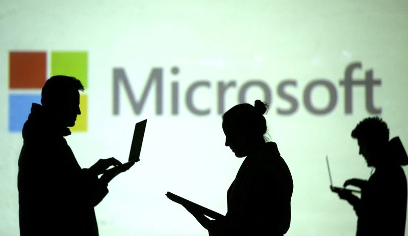 &copy; Reuters. FILE PHOTO: Silhouettes of laptop users are seen next to a screen projection of Microsoft logo in this picture illustration taken March 28, 2018.  REUTERS/Dado Ruvic/Illustration/File Photo
