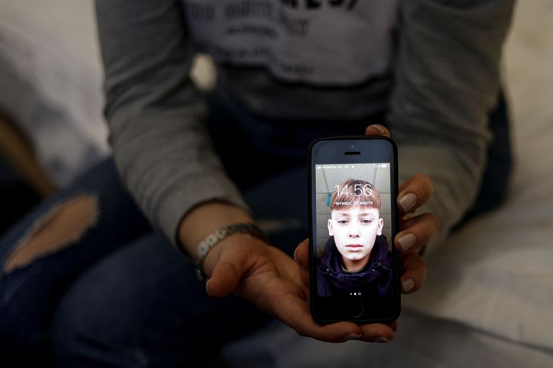 &copy; Reuters. امرأة تعرض صورة ابنها الذي نقل من أوكرانيا إلى روسيا في مقابلة مع رويترز يوم 30 مارس آذار 2023. رويترز