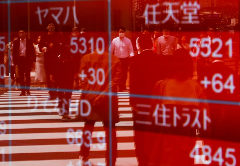 &copy; Reuters. FILE PHOTO: Passersby are reflected on an electric stock quotation board outside a brokerage in Tokyo, Japan April 18, 2023.  REUTERS/Issei Kato/File photo