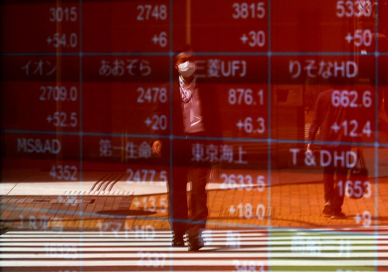 &copy; Reuters. FILE PHOTO: A man is reflected on an electric stock quotation board outside a brokerage in Tokyo, Japan April 18, 2023.  REUTERS/Issei Kato