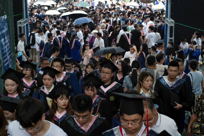 &copy; Reuters. FILE PHOTO: Graduates, including students who could not attend last year due to the coronavirus disease (COVID-19) pandemic, attend a graduation ceremony at Central China Normal University in Wuhan, Hubei province, China June 13, 2021. Picture taken June 