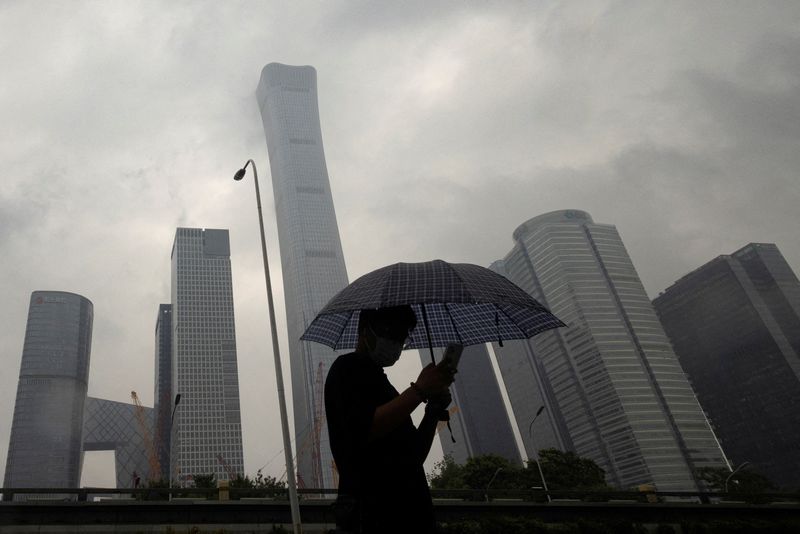 &copy; Reuters. FILE PHOTO: A man walks in the Central Business District on a rainy day, in Beijing, China, July 12, 2023. REUTERS/Thomas Peter/File Photo