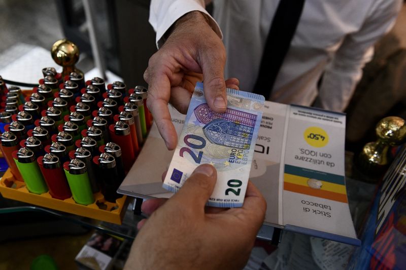&copy; Reuters. FILE PHOTO: A man uses cash to pay for items while shopping in Milan, Italy, October 2, 2020. Picture taken October 2, 2020. REUTERS/Flavio Lo Scalzo/File Photo