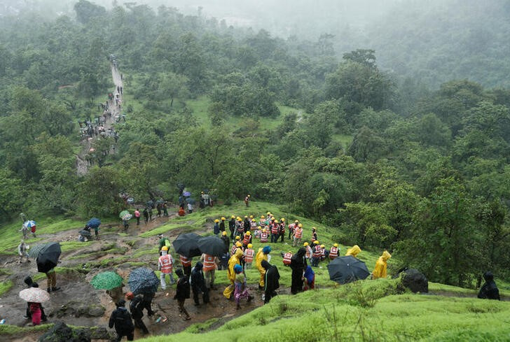 &copy; Reuters. インド東部で大規模な地滑りが発生し、２０日夜時点の死者が１６人となっている。写真は、現場に接近するために山を登る政府関係者ら。２０２３年７月２０日に撮影。（２０２３年　ロ