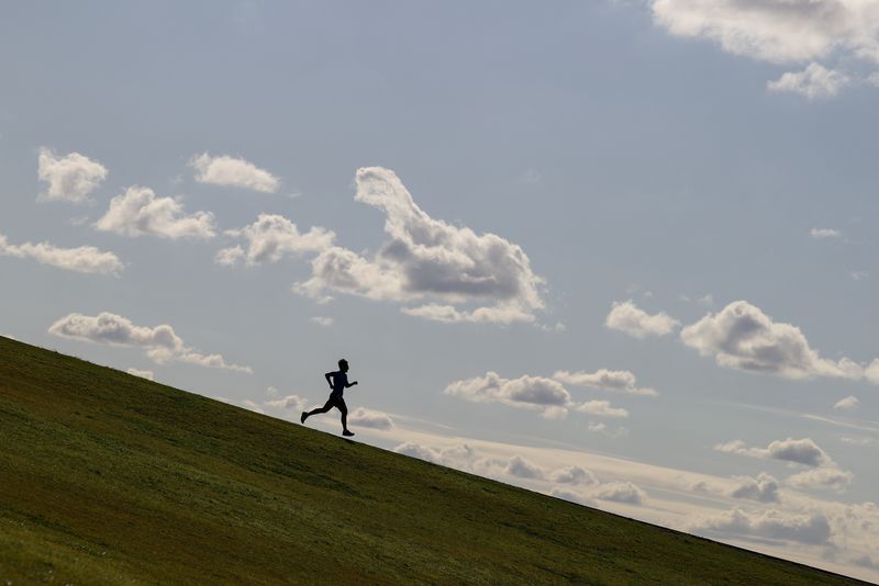 &copy; Reuters. FILE PHOTO: A runner exercises on a hill at Sydney Park in Sydney, Australia, June 26, 2020.  REUTERS/Loren Elliott/