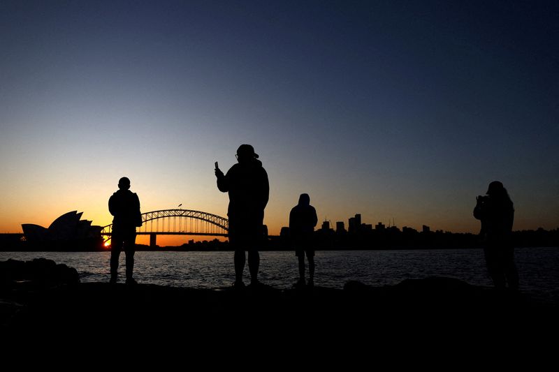 © Reuters. FILE PHOTO: Soccer Football - FIFA Women's World Cup Australia and New Zealand 2023 - Previews - Sydney, Australia - July 17, 2023 Silhouettes of people, the opera house and harbour bridge are seen during sunset ahead of the Women's World Cup REUTERS/Carl Recine/File Photo