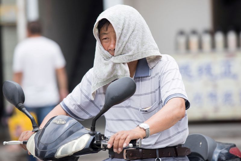 &copy; Reuters. FILE PHOTO: A man is seen with a towel tied around his head to escape hot weather as a heat wave hits Hangzhou, Zhejiang province, China, July 10, 2017. Picture taken July 10, 2017. REUTERS/Stringer/File Photo