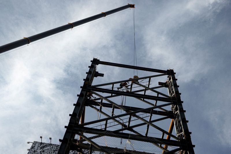 &copy; Reuters. FILE PHOTO: A worker stands on a metal structure in a shopping district in Beijing, China, July 14, 2023. REUTERS/Thomas Peter/File Photo