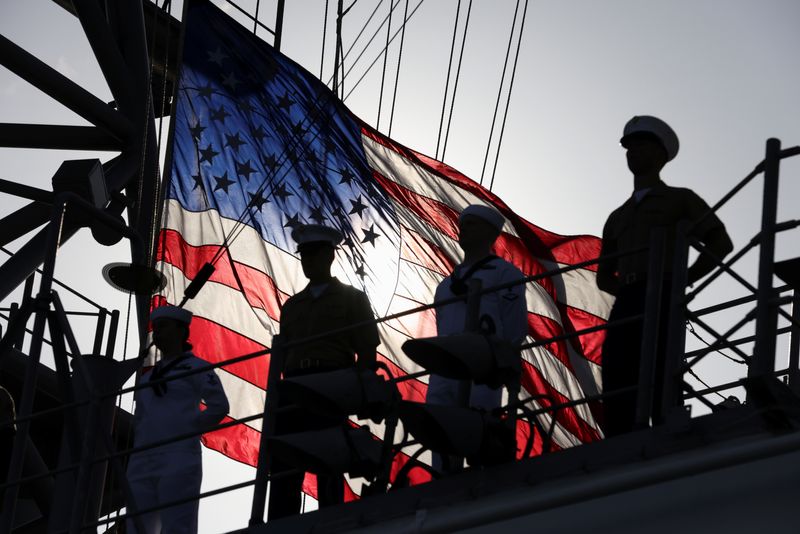 &copy; Reuters. A U.S. flag flutters in the background as members of the U.S. Marines and the U.S. Navy stand on a deck of the USS Bataan, a U.S. Navy Wasp-class amphibious assault ship, as it takes part in a parade of ships during Fleet Week 2022 in New York, U.S. May 2