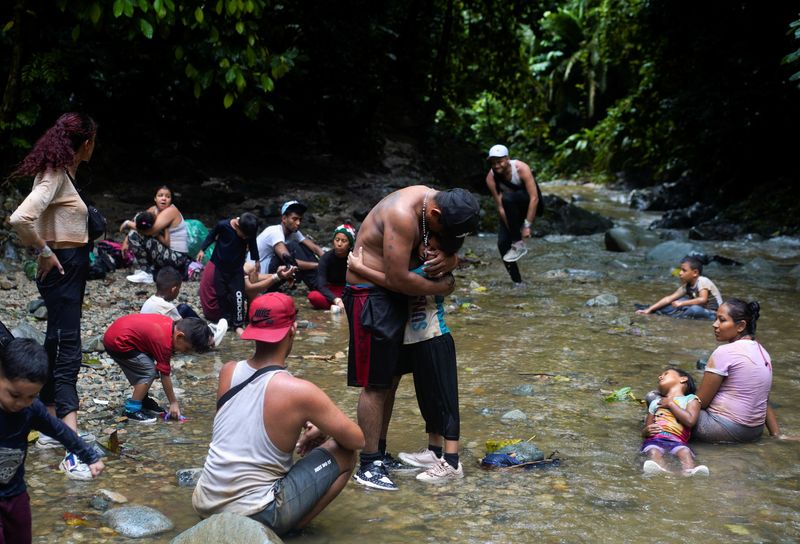 &copy; Reuters. FILE PHOTO: A migrant from Ecuador hugs his exhausted daughter, which is afraid after crossing the Rio Muerto river in the Darien Gap, as they continue their journey to the U.S. border, in Acandi, Colombia July 9, 2023. REUTERS/Adri Salido/File Photo