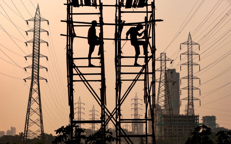&copy; Reuters. FILE PHOTO: Labourers work next to electricity pylons in Mumbai, India, October 13, 2021. REUTERS/Francis Mascarenhas/File Photo