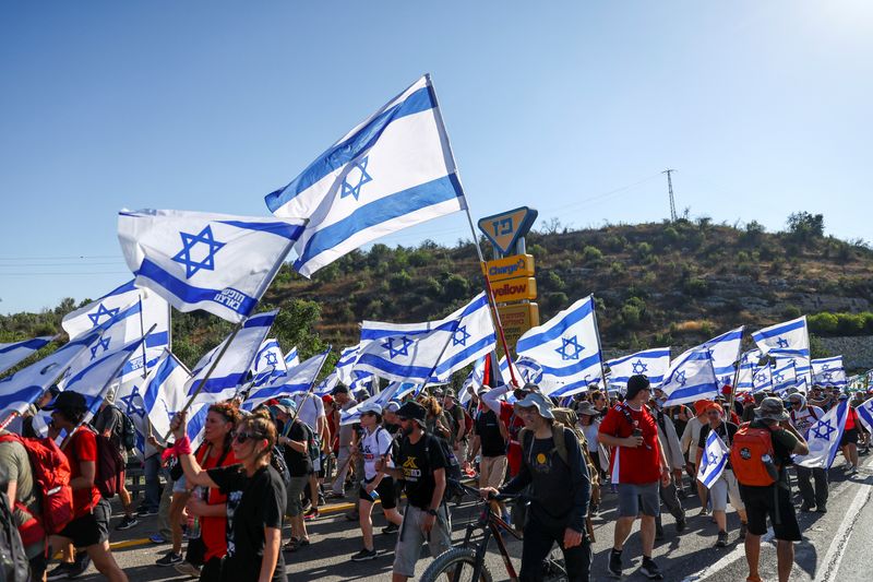 &copy; Reuters. محتجون يرفعون أعلام إسرائيل خلال مسيرة ضد رئيس الوزراء بنيامين نتنياهو والتعديلات القضائية في طريق مؤدية إلى القدس يوم الجمعة. تصوير: رونين