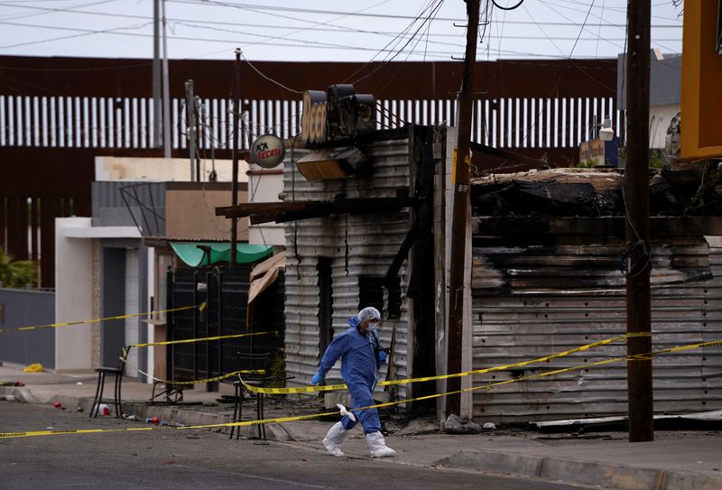 © Reuters. A forensic technician works at a scene where a man threw a Molotov cocktail bomb after being kicked out of a bar for bad behavior, leaving several victims, according to Sonora state authorities, in San Luis Rio Colorado, Mexico July 22, 2023. REUTERS/Victor Medina