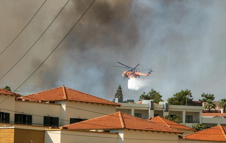 &copy; Reuters. Un helicóptero lanza agua sobre un incendio cerca de Lindos, en la isla de Rodas, Grecia. 22 julio 2023. REUTERS/Lefteris Damianidis NO REVENTAS NI ARCHIVOS.
