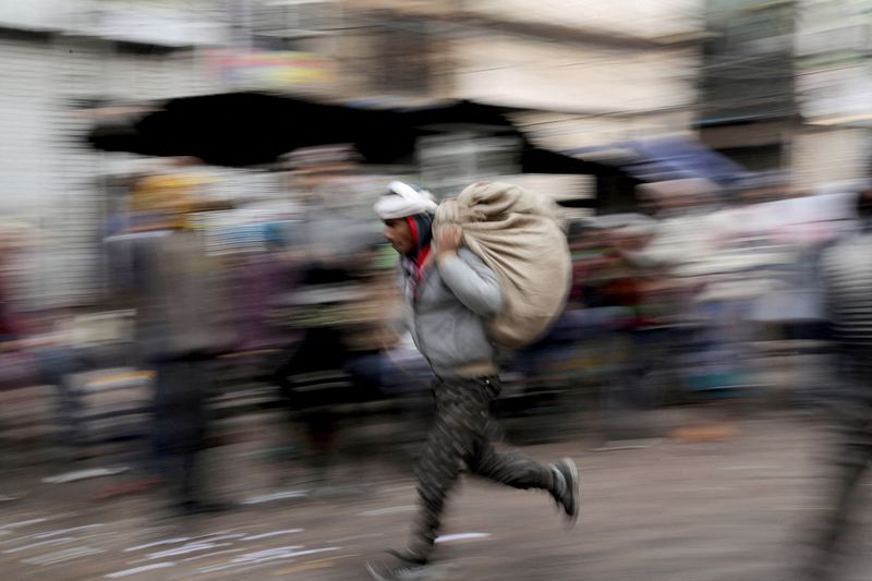 &copy; Reuters. FILE PHOTO: A labourer runs across a wholesale market in the old quarters of Delhi, India, January 7, 2020. REUTERS/Anushree Fadnavis/File Photo