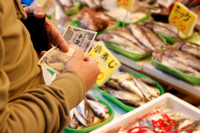 © Reuters. FILE PHOTO: A man buys fish at a market in Tokyo, Japan March 3, 2023. REUTERS/Androniki Christodoulou/File Photo