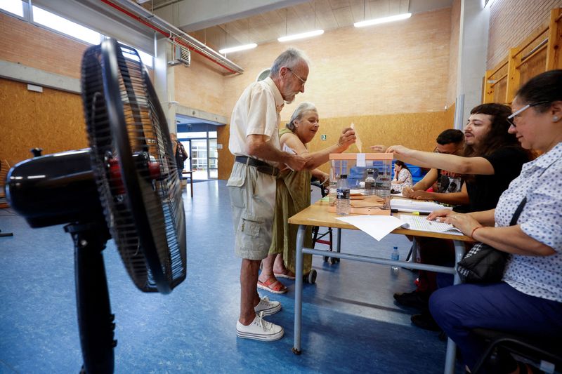 &copy; Reuters. A fan is placed to cool off as people cast their votes during a general snap election at a polling station in Barcelona, Spain, July 23, 2023. REUTERS/Albert Gea/File Photo