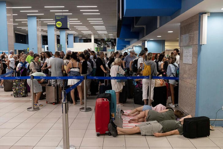 &copy; Reuters. Varios turistas duermen en el suelo mientras otros hacen cola ante los mostradores del aeropuerto de Rodas, Grecia. 24 julio 2023. REUTERS/Nicolas Economou