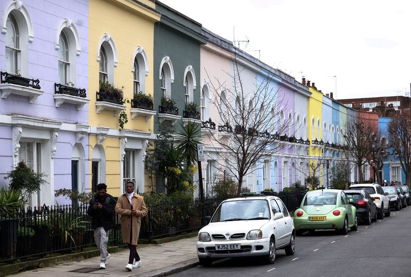 &copy; Reuters. FILE PHOTO: People walk past a row of colourful houses in London, Britain, March 19, 2023. REUTERS/Henry Nicholls/File Photo