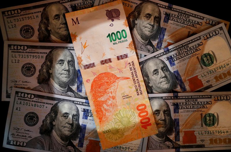 &copy; Reuters. A one thousand Argentine peso bill sits on top of several one hundred U.S. dollar bills in this illustration picture taken October 17, 2022. REUTERS/Agustin Marcarian/Illustration
