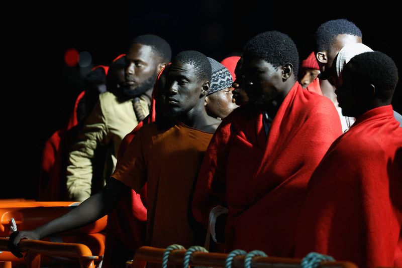 &copy; Reuters. Migrantes esperan para desembarcar de un buque guardacostas español, en el puerto de Arguineguín, en la isla de Gran Canaria. España. 25 de julio de 2023. REUTERS/Borja Suárez