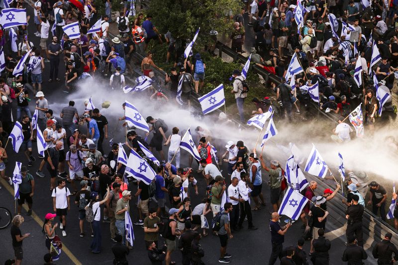 © Reuters. الشرطة تستخدم خراطيم المياه لتفريق متظاهرين يغلقون الطريق المؤدية إلى مكتب رئيس الوزراء الإسرائيلي بنيامين نتنياهو في القدس يوم الاثنين. تصوير: رونين زفولون - رويترز.