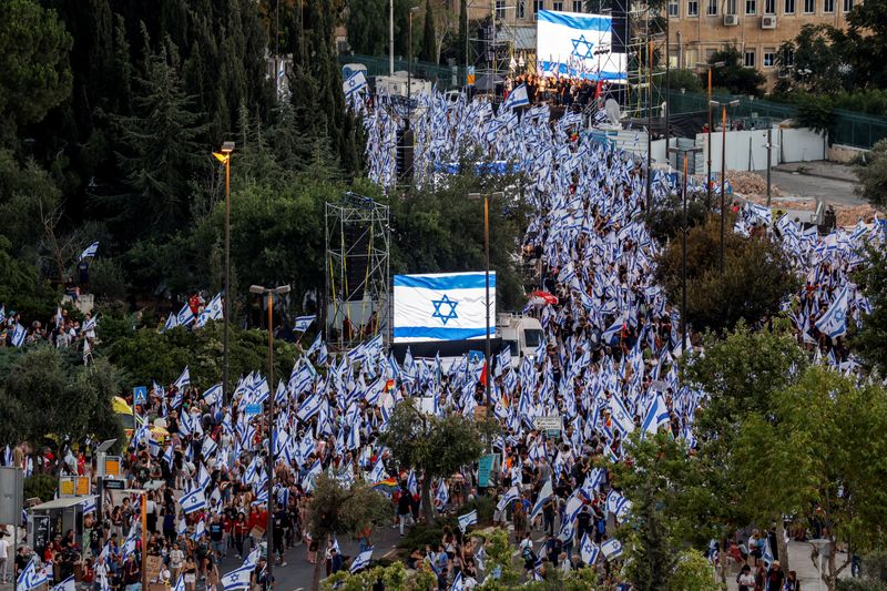 &copy; Reuters. FILE PHOTO: Protesters hold Israeli flags as they demonstrate following a parliament vote on a contested bill that limits Supreme Court powers to void some government decisions, near the Knesset, Israel's parliament in Jerusalem July 24, 2023. REUTERS/Ami