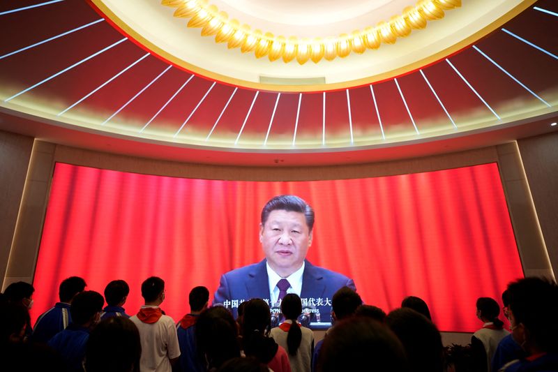 © Reuters. FILE PHOTO:  Secondary school students gather in front of a screen displaying an image of Chinese President Xi Jinping, at the Memorial of the First National Congress of the Communist Party of China in Shanghai, China  March 10, 2023. REUTERS/Aly Song/File Photo