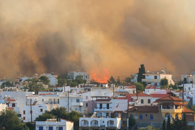&copy; Reuters. FILE PHOTO: Flames and smoke rise as a wildfire burns near the village of Gennadi, on the island of Rhodes, Greece, July 25, 2023. REUTERS/Nicolas Economou/File Photo