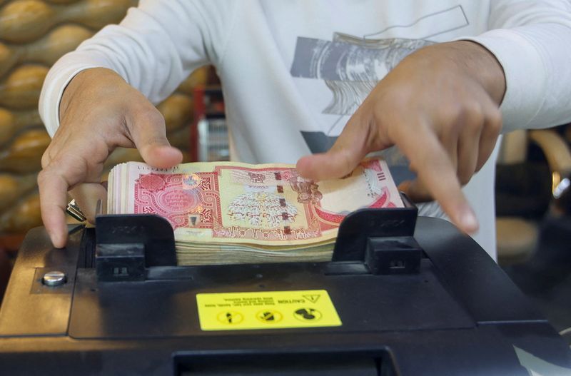 &copy; Reuters. A man counts Iraqi dinars on a money counting machine at a currency exchange shop in Baghdad, Iraq, January 23, 2023. REUTERS/Ahmed Saad