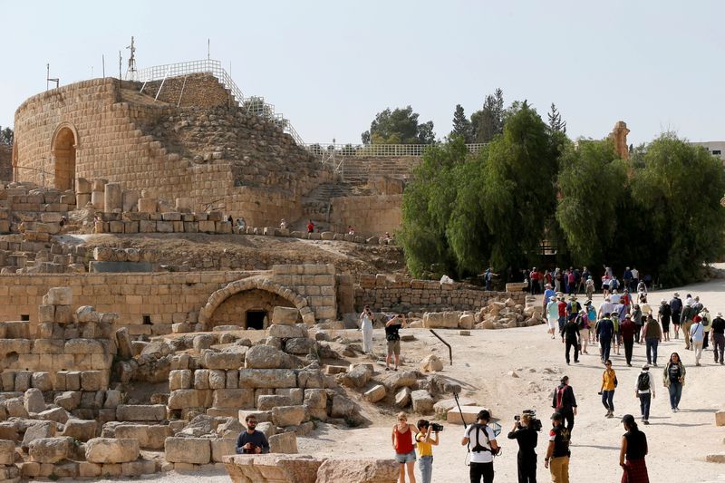 © Reuters. سياح يسيرون إلى جانب الآثار الرومانية القديمة خلال زيارتهم لمدينة جرش الأثرية بالأردن في صورة من أرشيف رويترز . 
