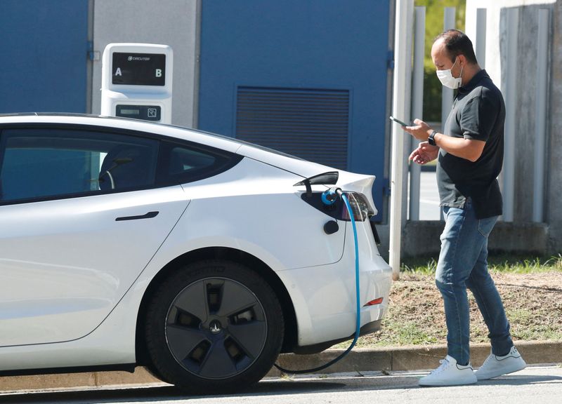 &copy; Reuters. Homem olha celular enquanto carrega bateria de seu Tesla perto de Barcelona
17/09/2021 REUTERS/Albert Gea