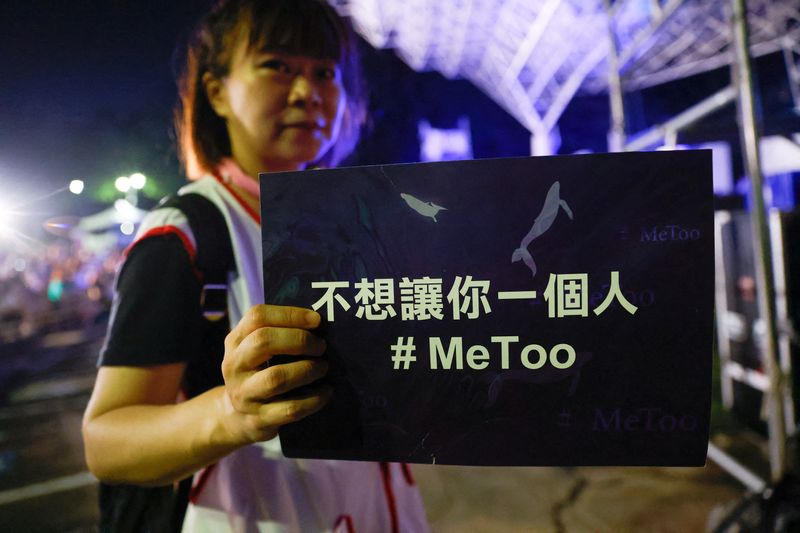 © Reuters. FILE PHOTO: A volunteer holds a placard at a concert to support #MeToo movement in Taipei,Taiwan July 22, 2023. REUTERS/Ann Wang/File Photo