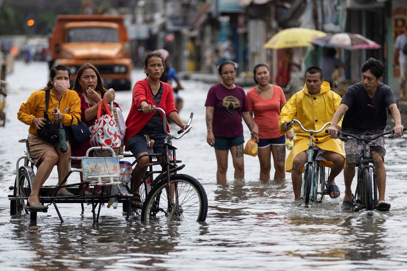 &copy; Reuters. Commuters wade through a flooded street in the aftermath of typhoon Doksuri, in Valenzuela, Metro Manila, Philippines July 27, 2023. REUTERS/Eloisa Lopez