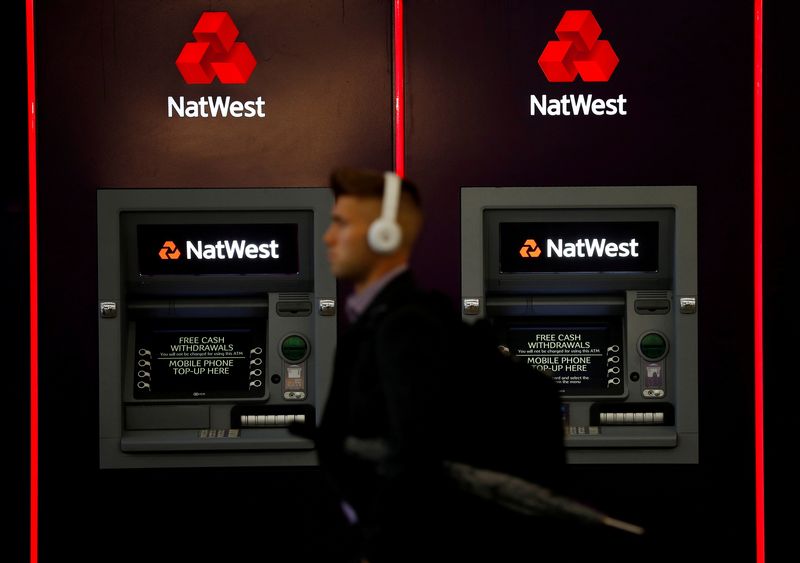 &copy; Reuters. Un uomo passa davanti ai bancomat della filiale della banca NatWest di Manchester, Gran Bretagna. REUTERS/Phil Noble/File Photo