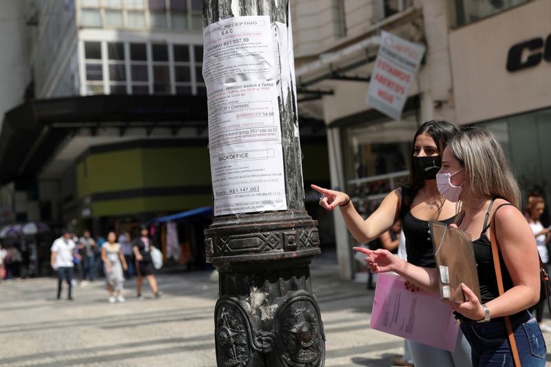 &copy; Reuters. FOTO DE ARCHIVO. Mujeres observan afiches de anuncios de empleo colocados en un poste luz en el centro de Sao Paulo, Brasil. 30/09/2020. REUTERS/Amanda Perobelli