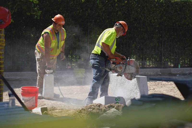 &copy; Reuters. FILE PHOTO: Construction workers fix a sidewalk, during a heatwave in Boston, Massachusetts, U.S. July 21, 2022.  REUTERS/Allison Dinner/File Photo