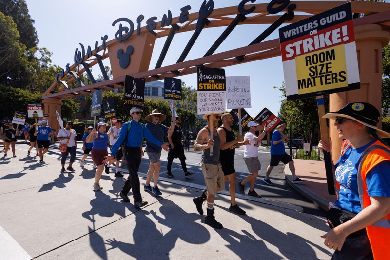 &copy; Reuters. SAG-AFTRA actors and Writers Guild of America (WGA) writers walk the picket line outside Disney Studios in Burbank, California, U.S., July 25, 2023.   REUTERS/Mike Blake/File Photo