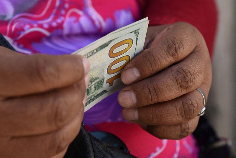 &copy; Reuters. Negociador informal de câmbio segura notas de dólar em uma rua de La Paz
06/03/2023
REUTERS/ Claudia Morales